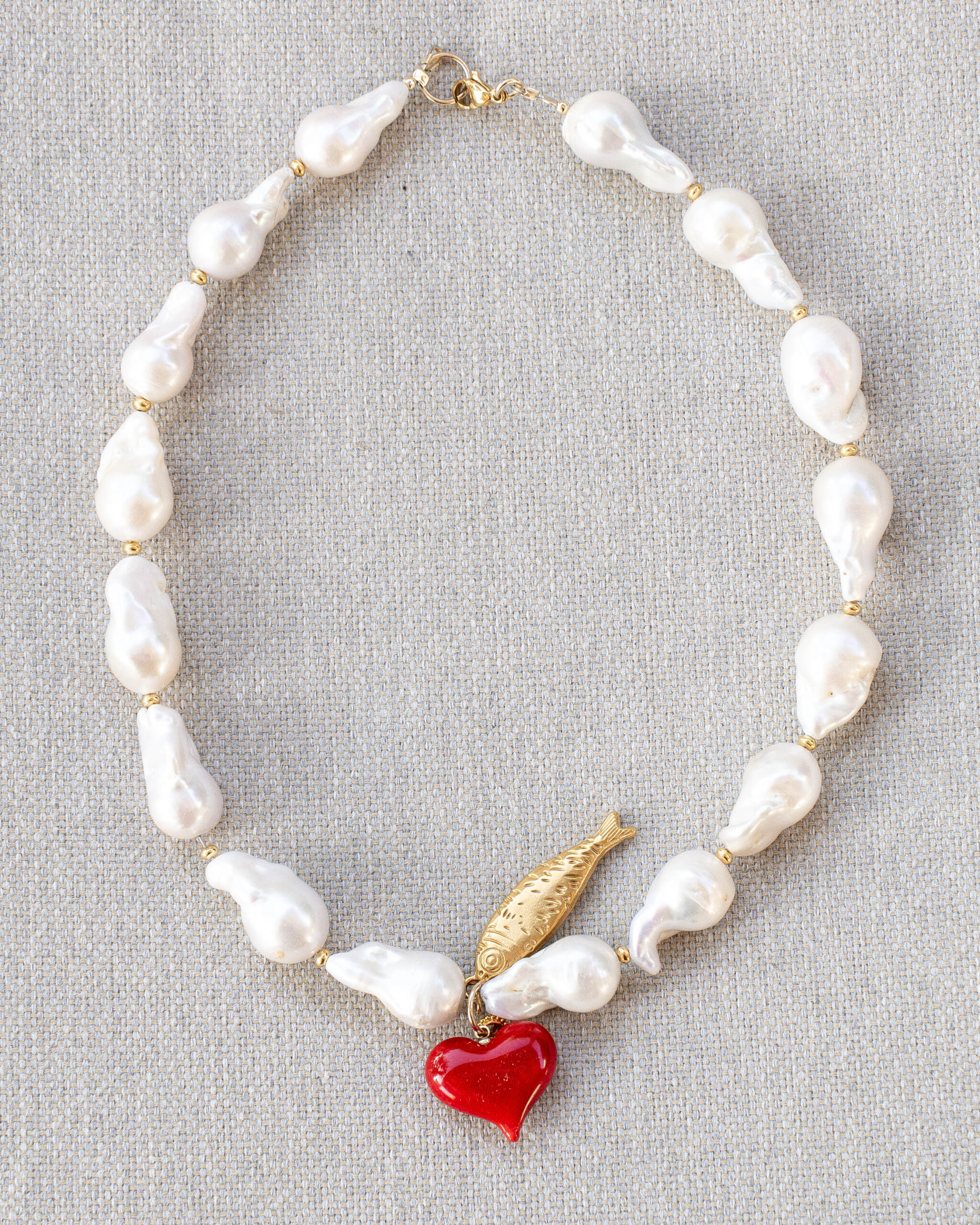 Unique baroque pearls for a boutique look with a lucky fish and a red glass heart