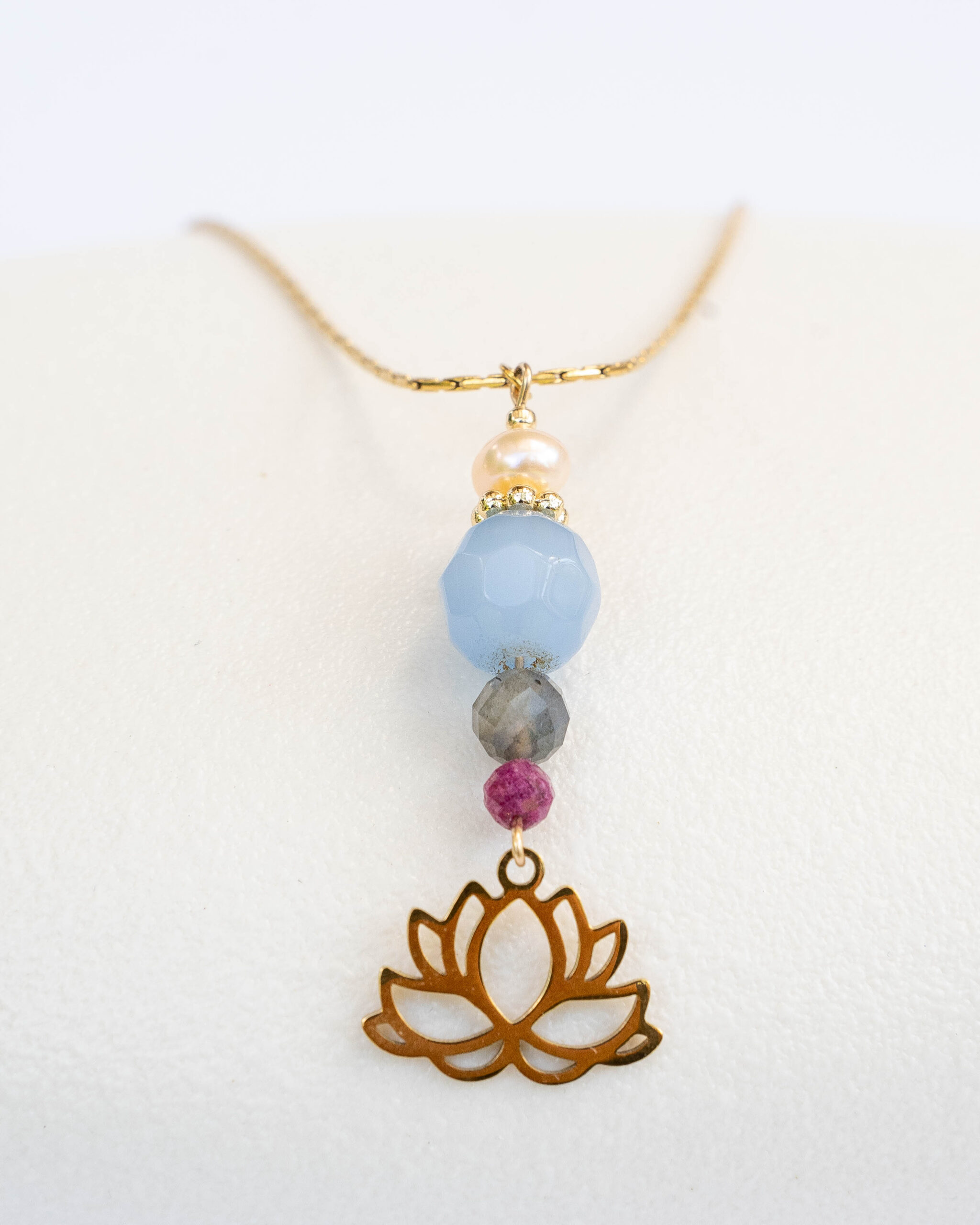 Long gold necklace with a pendant designed with ruby, aquamarine, labradorite and pink pearl combined with a lotus